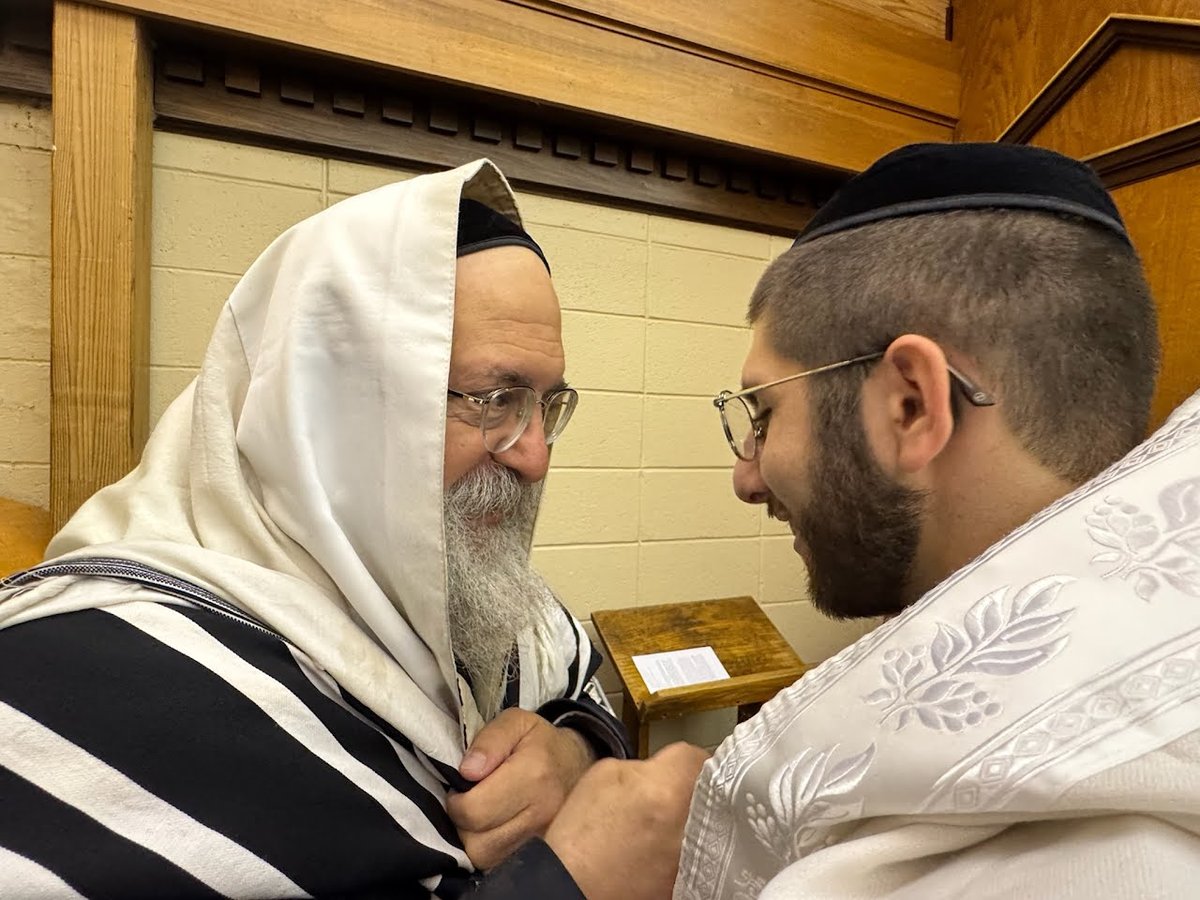 A warm moment between the sandek and the mohel during the ceremony